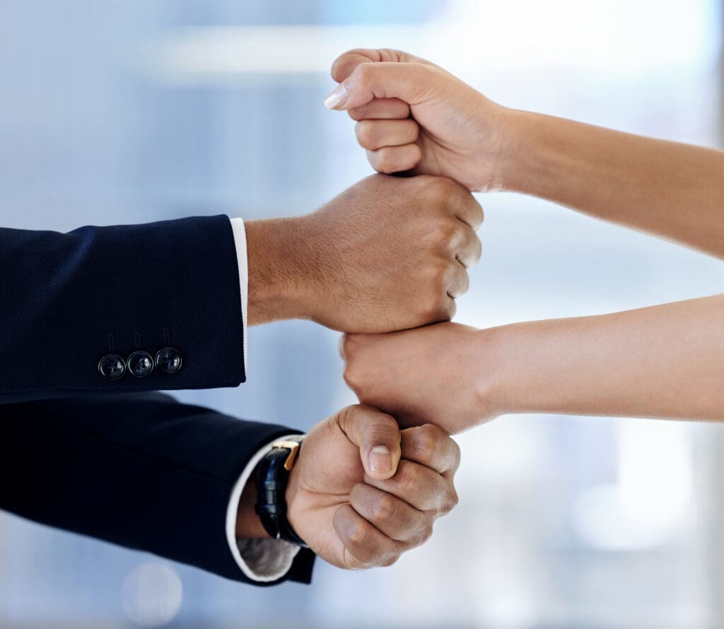 Hands stacked on top of each other, signifying successful business acquisitions